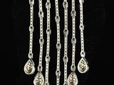 a close up of a silver necklace on a black background