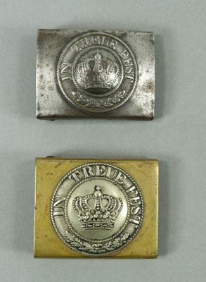 two silver and gold metal buttons with a crown on them