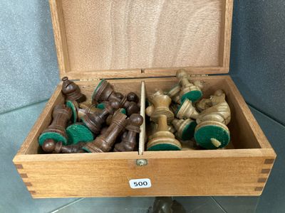 a wooden box filled with chess pieces on a tile floor