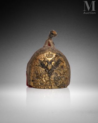 an old bell with a bird on it sitting on top of a table