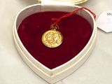 a heart shaped box with a gold medal in it