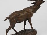 sculpture en bronze représentant un cerf debout sur un rocher, sur fond blanc