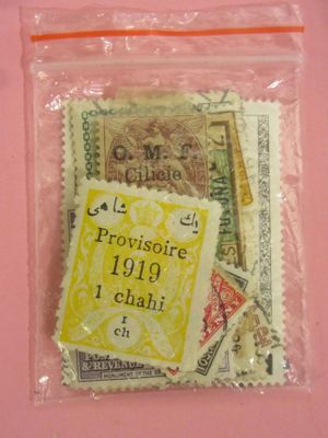 un sachet de timbres-poste posé sur un fond rose