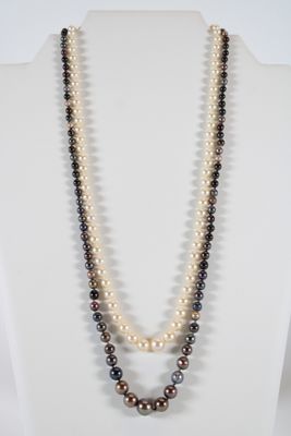 a close up of a necklace with pearls on a mannequin