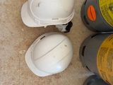three hard hats sitting on the floor next to a fire hydrant