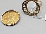 a coin and a ring on a table next to each other