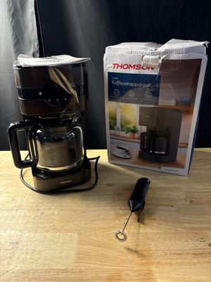 une cafetière posée sur une table à côté d'une boîte