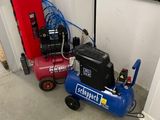 two air compressors sitting next to each other in a garage