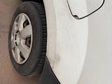 a white car with a flat tire on the side of the road