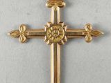 a close up of a gold cross on a white surface