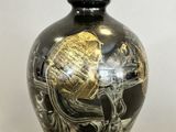 a black and gold vase sitting on a table