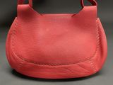 a close up of a red purse on a black background