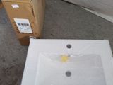 a white sink sitting on the floor next to a cardboard box