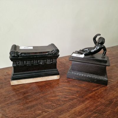 deux statues représentant un homme et un chien, posées sur une table