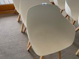 several white chairs are lined up in a row in front of a window