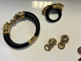 two pieces of jewelry are sitting on a table next to a coin