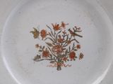 a white plate with a design of flowers and birds on it