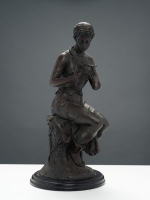 une statue en bronze représentant une femme assise sur une souche d'arbre
