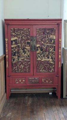 une armoire rouge dans une pièce au sol en parquet