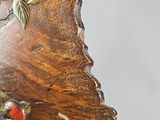 a close up of a wooden clock with a bird on it