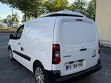 une camionnette blanche garée sur un parking à côté d'un bâtiment