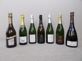 six bouteilles de vin sont alignées sur une table