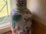 un vase posé sur le rebord d'une fenêtre, devant celle-ci