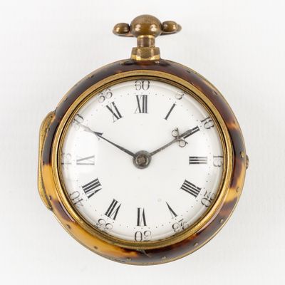 une horloge en or avec des chiffres romains sur le cadran