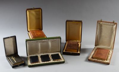 quatre petites boîtes contenant différents types de bijoux, posées sur une surface blanche