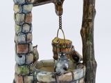a ceramic figurine of a well with birds on it