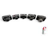 several old cameras are lined up in a row on a white surface