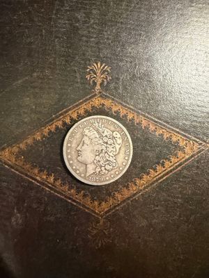 une pièce d'argent posée sur un livre noir