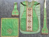 un tissu vert orné d'une croix, à côté d'une brosse à dents et d'autres objets