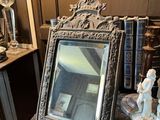 un miroir et une statue posés sur une table dans une pièce