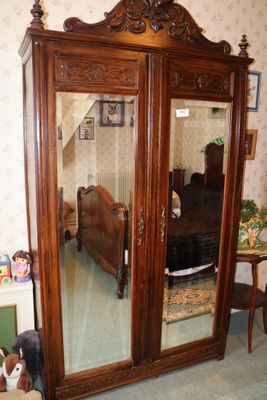 une grande armoire en bois munie d'un miroir