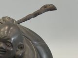 a statue of a laughing man with a stick in his hand