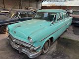 many old cars parked in a garage next to each other