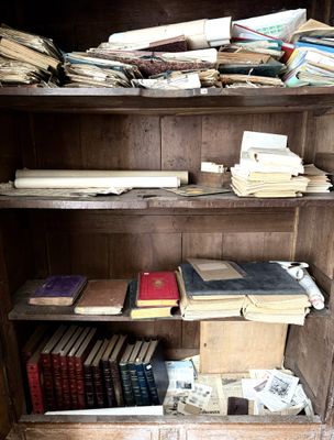 Des livres sont empilés sur une étagère en bois dans une pièce