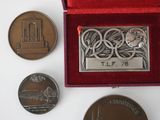 three medals and a medal in a red box on a white surface