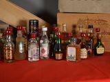 many bottles of alcohol sitting on a table with a red table cloth