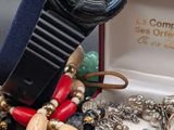 a watch sitting in a red box with a bunch of jewelry