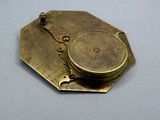a brass plate with a clock on it on a table