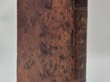 an old book sitting on top of a white surface