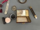a small box with a mirror, a pen, a mirror, and a pair of scissors on a table