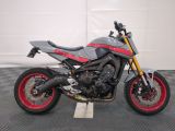 a motorcycle parked on a checkered floor in a garage