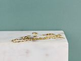 une paire de boucles d'oreilles en or posée sur un bloc de marbre blanc