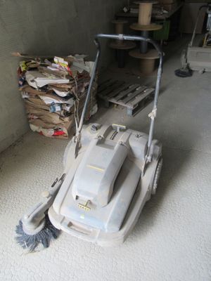 a mop that is sitting on the floor next to a pile of trash