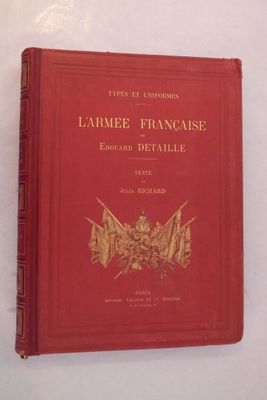 un vieux livre posé sur une table blanche, avec une couverture rouge