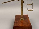 an image of a brass scale with a wooden base and a wooden handle