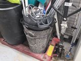 a pile of trash in a garage with a lot of tools